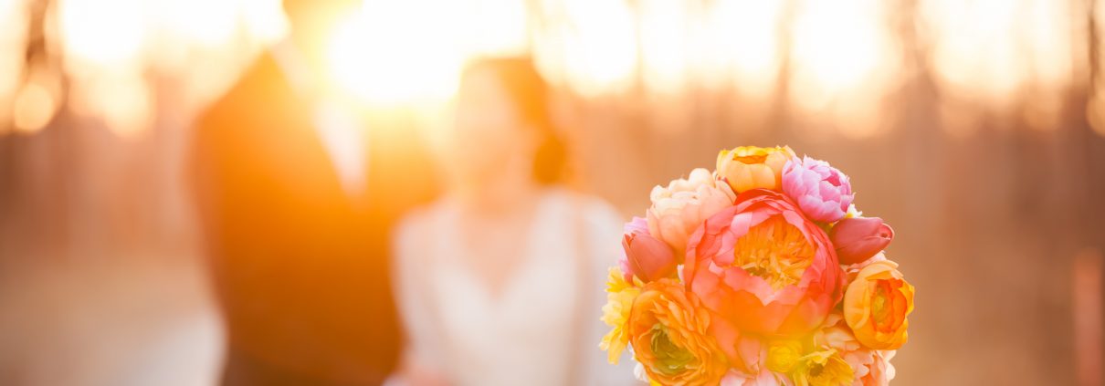 Newlyweds with the bride's gorgeous bouquet enjoying sunset together